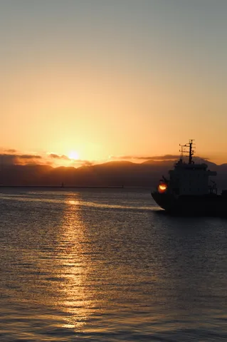 夕暮れの船出、海と空のコントラスト