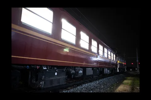 夜の車窓を照らす列車の影