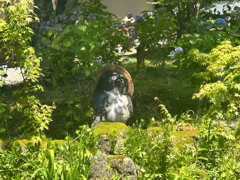 緑に囲まれた狸の置物
