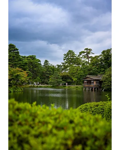 静寂の日本庭園、水面に映る旧き良き建物