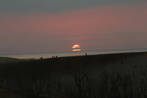 水平線に沈む夕日と人影