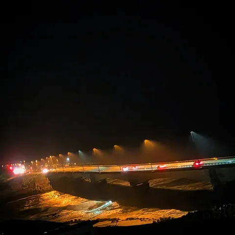 夜の橋、車の光跡が流れる