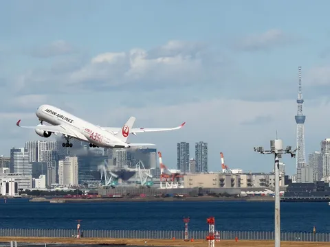 離陸するJAL機と都市の風景