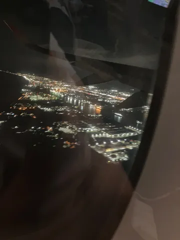 地上を彩る夜景と飛行機窓