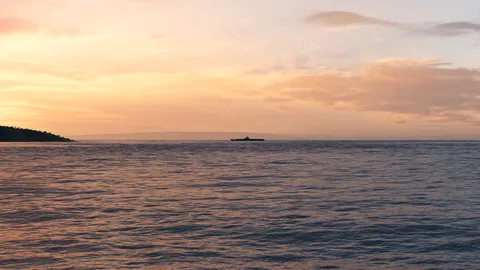 静寂に浮かぶ船、夕暮れの海