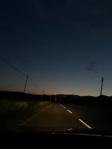 夕暮れの一本路に灯る影