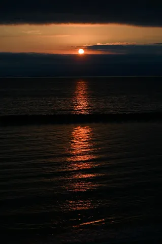 静寂の海に灯る夕日の道