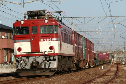 赤と白の機関車が走る貨物列車