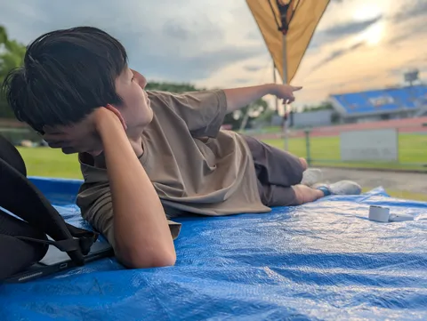 夕暮れ時のスタジアム、指差す先には