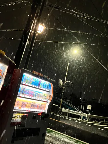 夜の雪と自販機の灯り