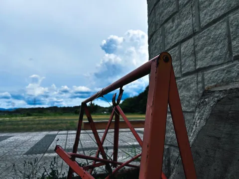 錆びたブランコと石壁のコントラスト