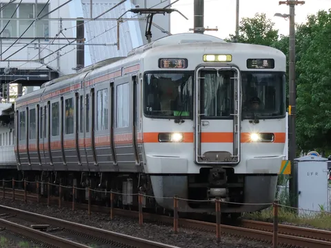 橙色の帯が走る朝の列車