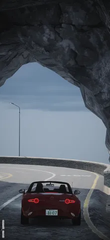 海風を抜ける赤いオープンカー