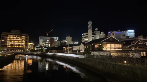 夜の川辺に映る街の影