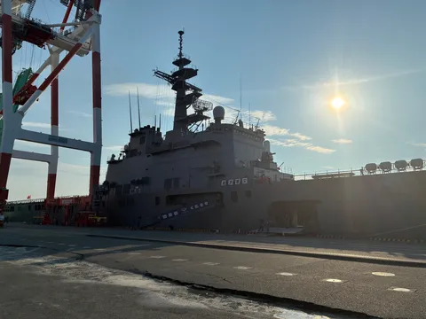 出港を待つ巨大な軍艦、夕陽に染まる