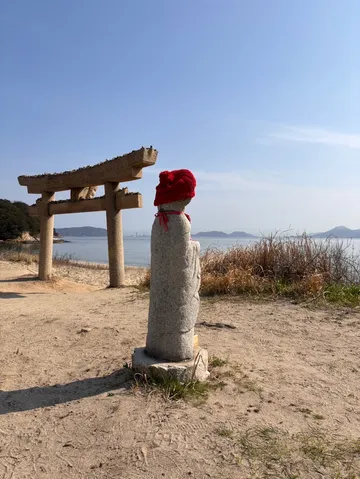海辺の鳥居と赤い帽子