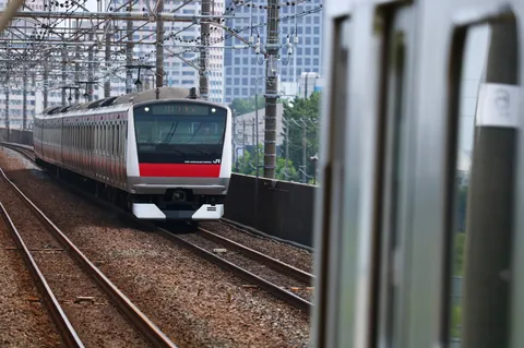 疾走するE233系、都会と郊外の境界線