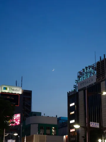 宵闇に浮かぶ三日月と街の灯り