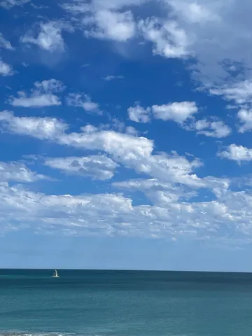広がる青い空と海、白い帆