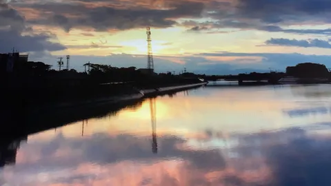 夕焼けに染まる水面と鉄塔