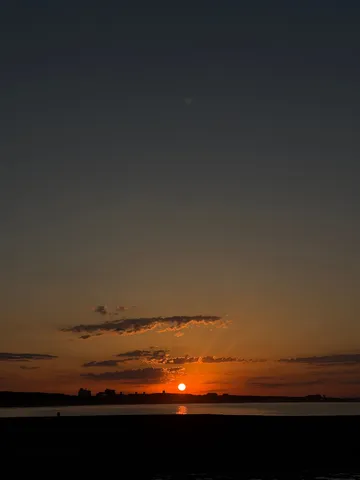水平線に沈む夕日と街並み