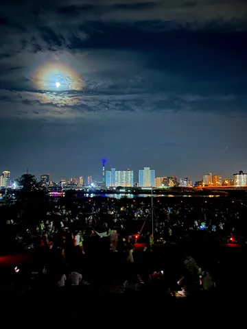 月光に照らされる夜の街と人々の賑わい