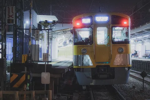 雪舞う駅、黄色い列車の灯り