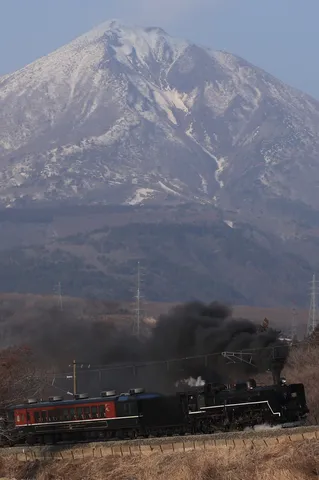 雪化粧の山と黒煙の蒸気機関車
