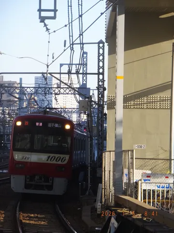 朝の駅線路を走る赤列車