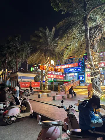 ネオンとヤシの木、夜市の賑わい
