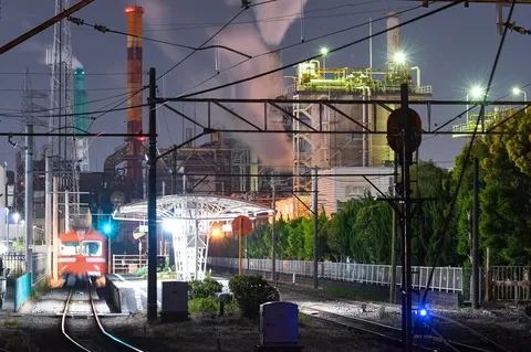 煌めく工場の夜と走り去る電車