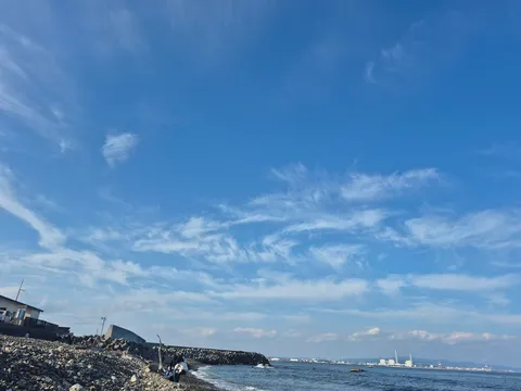 海岸に広がる空と産業のコントラスト
