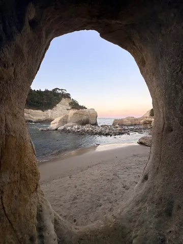 洞窟から覗く夕暮れの海岸