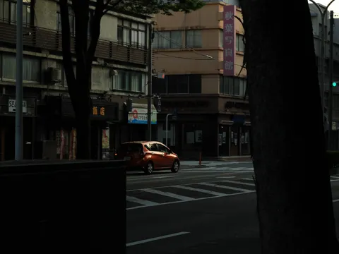 夕暮れの街角、オレンジ色の車