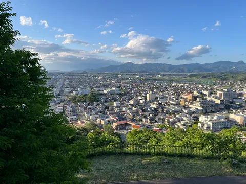 見下ろす街並み、雲と山々のコントラスト