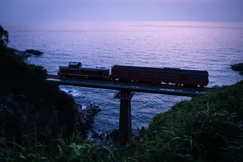 夕暮れの海辺を駆ける列車