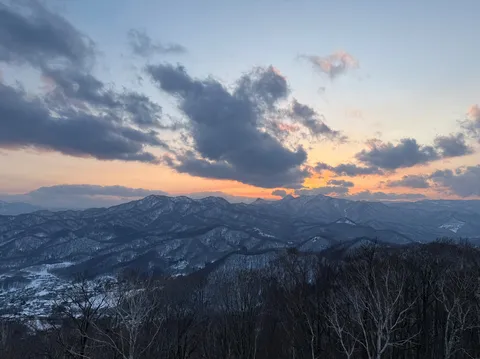 夕暮れの雪山に沈む太陽