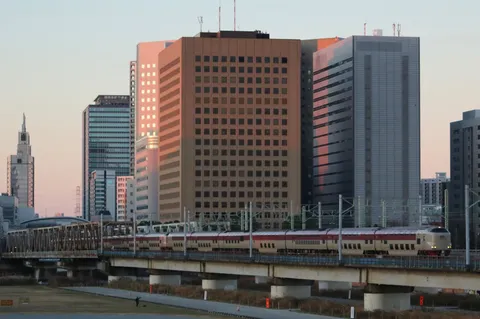 夕陽に染まる都会の鉄道風景