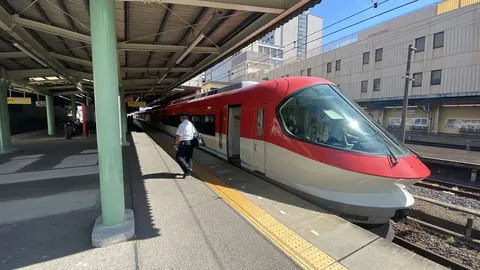 停車中の赤い列車と駅員さん