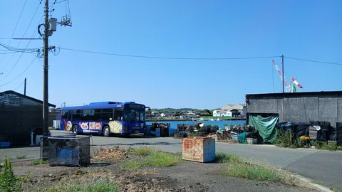 港の空と青いバスの影