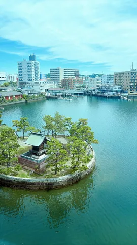 水面に浮かぶ緑の小島と建物