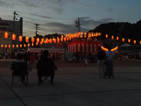 祭りの夜、灯りに照らされる人影