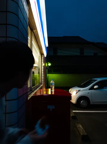 夜のコンビニとポスト、佇む車