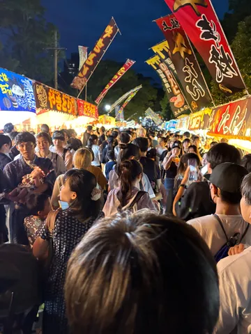祭りの夜、光と人々の賑わい