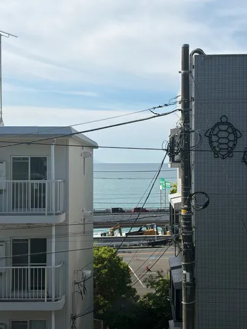 電線と青い海、穏やかな日常の風景