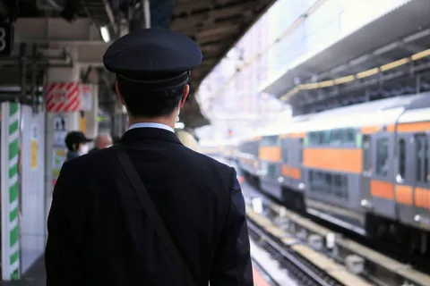 駅に立つ制帽の背中