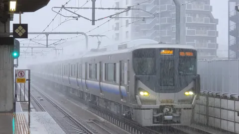 雨煙る駅の停車風景