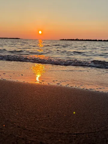 海辺の夕日、波打ち際の輝き