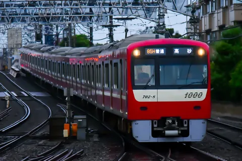 架線の下を走る赤い列車