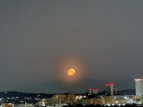 オレンジに輝く月と都会の夜